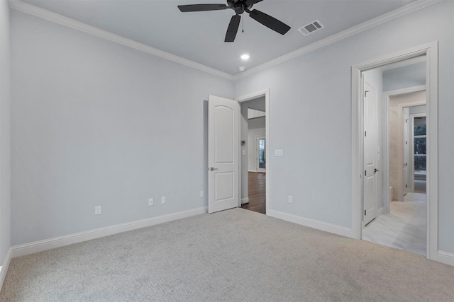 unfurnished bedroom with ceiling fan, light colored carpet, and crown molding