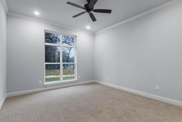 carpeted spare room featuring ceiling fan and crown molding