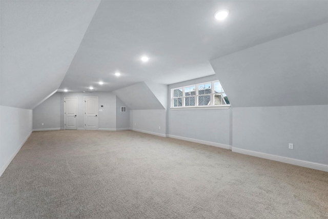 additional living space with vaulted ceiling and light carpet