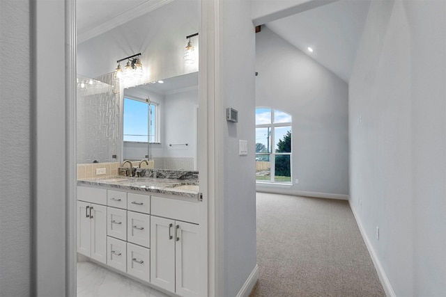 bathroom featuring vanity, vaulted ceiling, a wealth of natural light, and crown molding