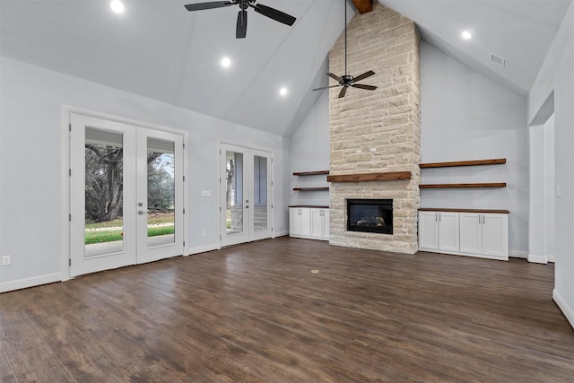 unfurnished living room with french doors, dark wood-type flooring, beam ceiling, a fireplace, and high vaulted ceiling