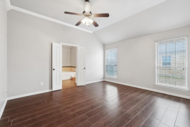 spare room featuring dark wood-type flooring, vaulted ceiling, ceiling fan, and ornamental molding