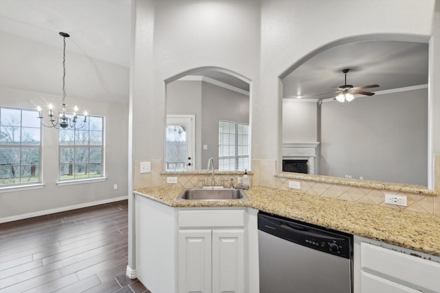 kitchen with light stone countertops, stainless steel dishwasher, sink, white cabinets, and backsplash