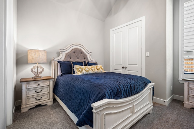 bedroom featuring dark colored carpet, a closet, and vaulted ceiling