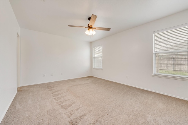 empty room featuring ceiling fan and light carpet