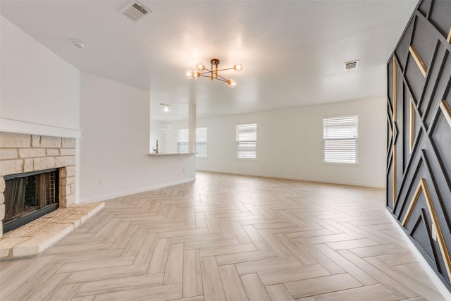 unfurnished living room featuring a fireplace, plenty of natural light, a chandelier, and light parquet floors