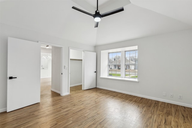 unfurnished bedroom with ceiling fan, hardwood / wood-style floors, and lofted ceiling