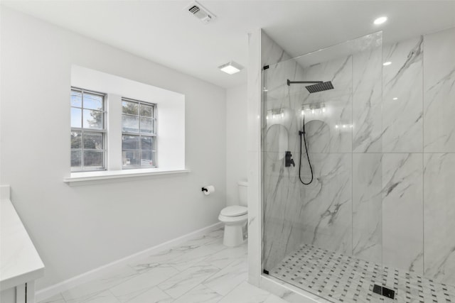 bathroom with vanity, toilet, and tiled shower