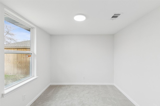 unfurnished room featuring a wealth of natural light and light colored carpet