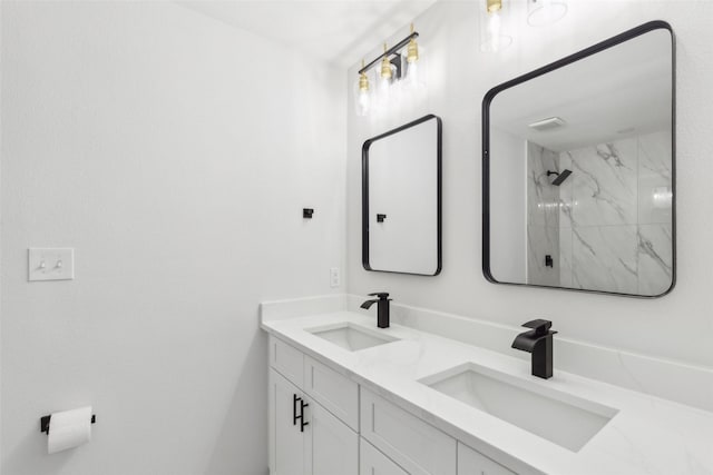 bathroom featuring tiled shower and vanity