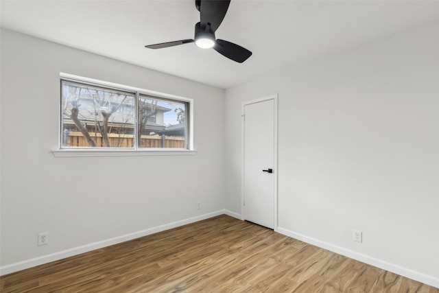 unfurnished bedroom featuring ceiling fan, multiple windows, and light wood-type flooring