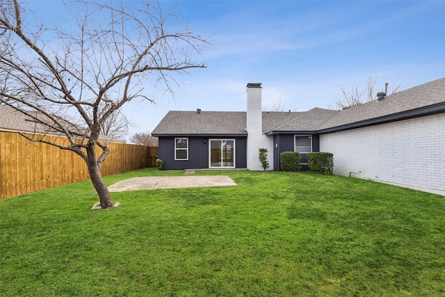 rear view of house with a patio and a lawn