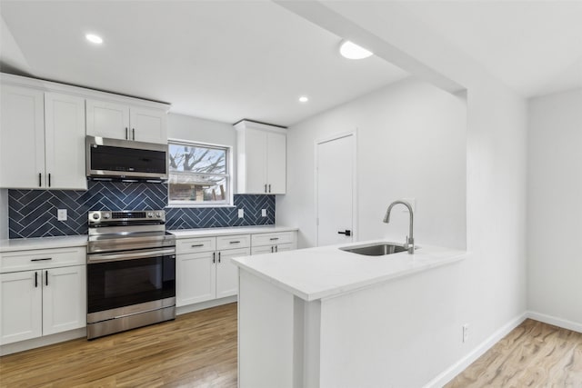 kitchen with sink, white cabinets, appliances with stainless steel finishes, and light hardwood / wood-style flooring