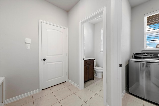 clothes washing area featuring washer / dryer and light tile patterned floors