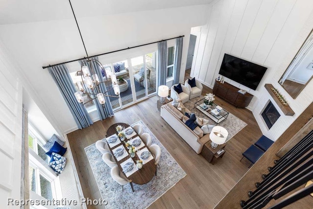 living room featuring light hardwood / wood-style flooring, high vaulted ceiling, and a notable chandelier