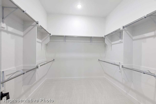 spacious closet featuring light carpet