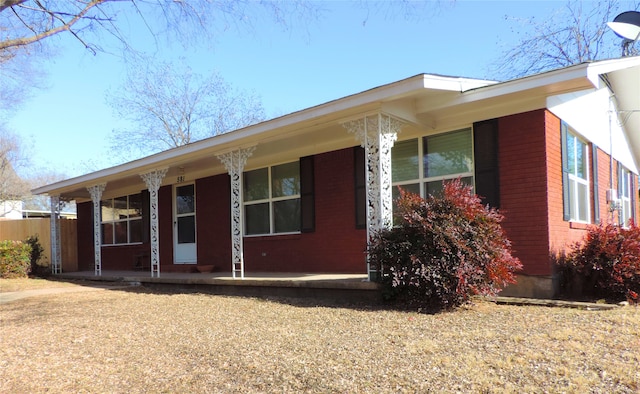 ranch-style home with a porch and brick siding