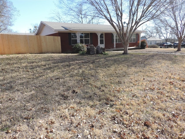 ranch-style house with fence and a front yard