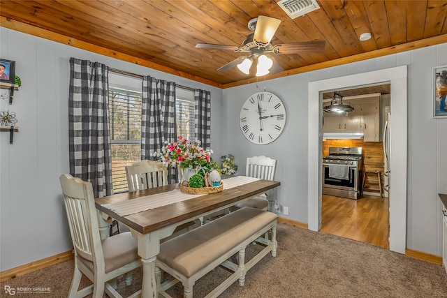 carpeted dining space featuring wooden ceiling and ceiling fan