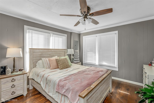 bedroom featuring ceiling fan, wood walls, crown molding, and dark wood-type flooring