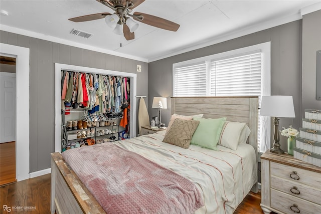 bedroom featuring ceiling fan, dark wood-type flooring, a closet, and ornamental molding