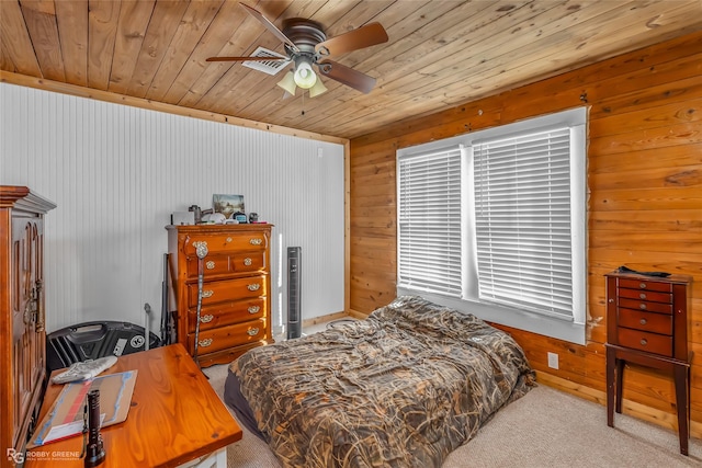 carpeted bedroom with ceiling fan, wooden ceiling, and wooden walls