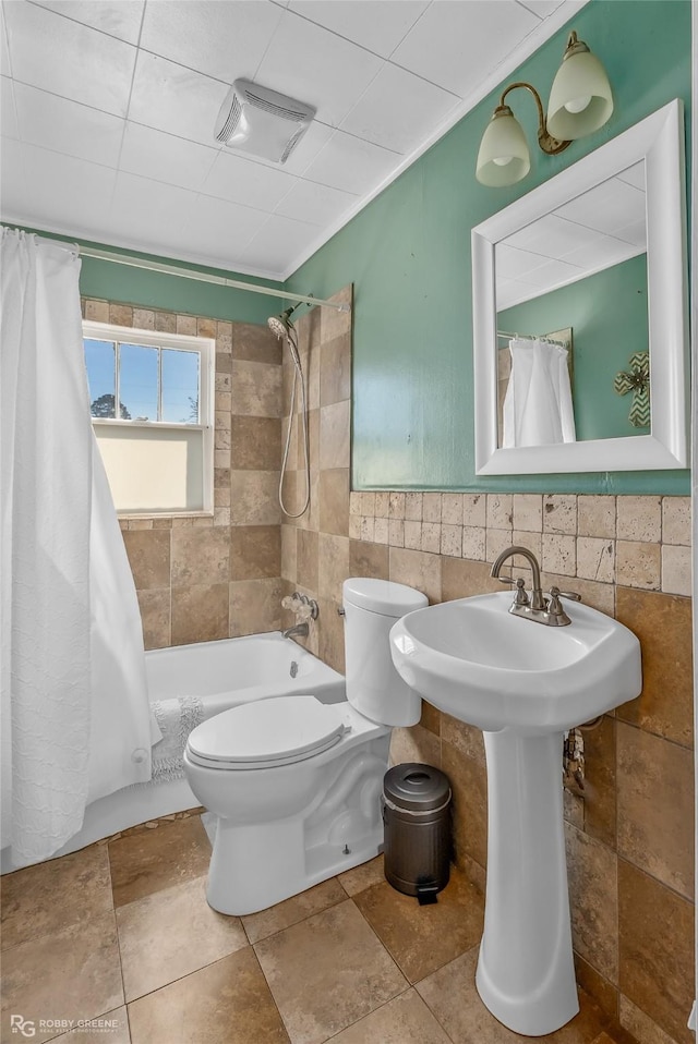 bathroom featuring toilet, tile walls, and shower / bath combo