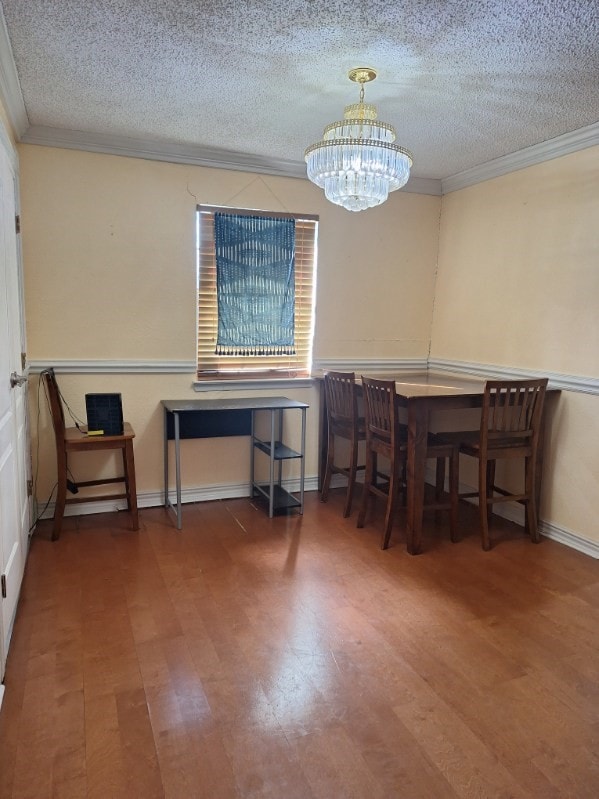 dining room featuring a chandelier, crown molding, and a textured ceiling