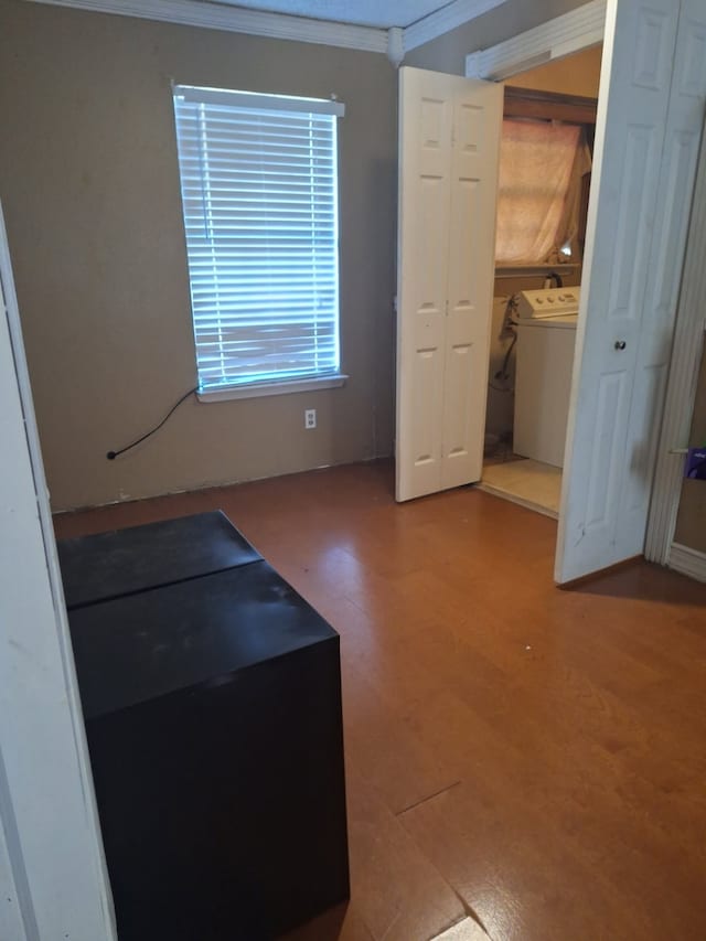 interior space featuring washer / dryer, crown molding, and wood finished floors