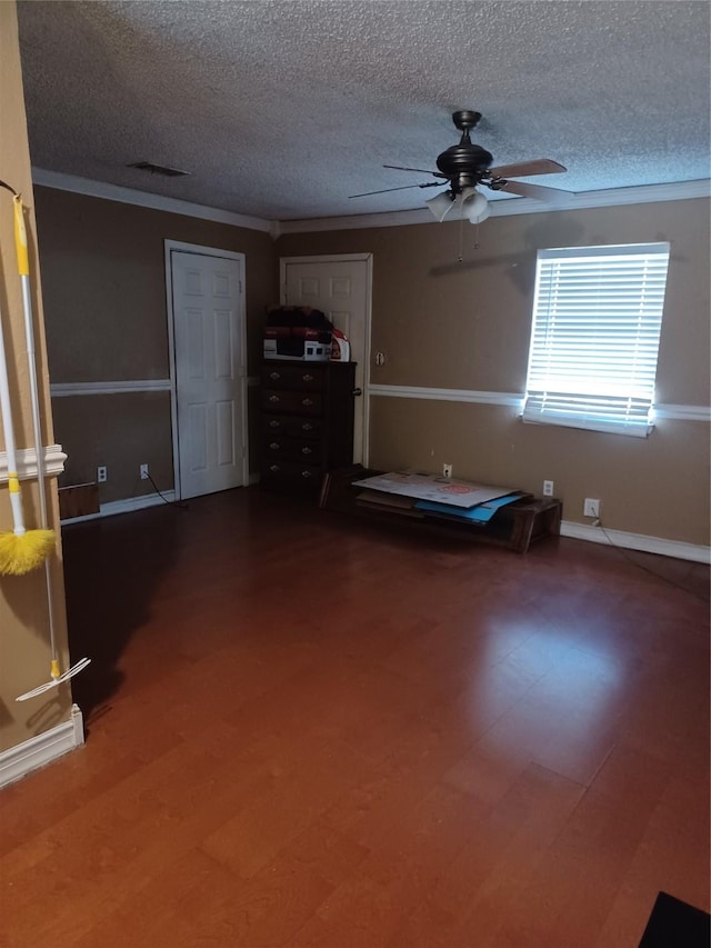 unfurnished bedroom featuring a ceiling fan, a textured ceiling, visible vents, and wood finished floors