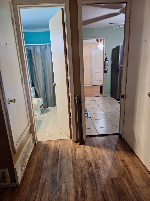 hallway with wood finished floors and visible vents