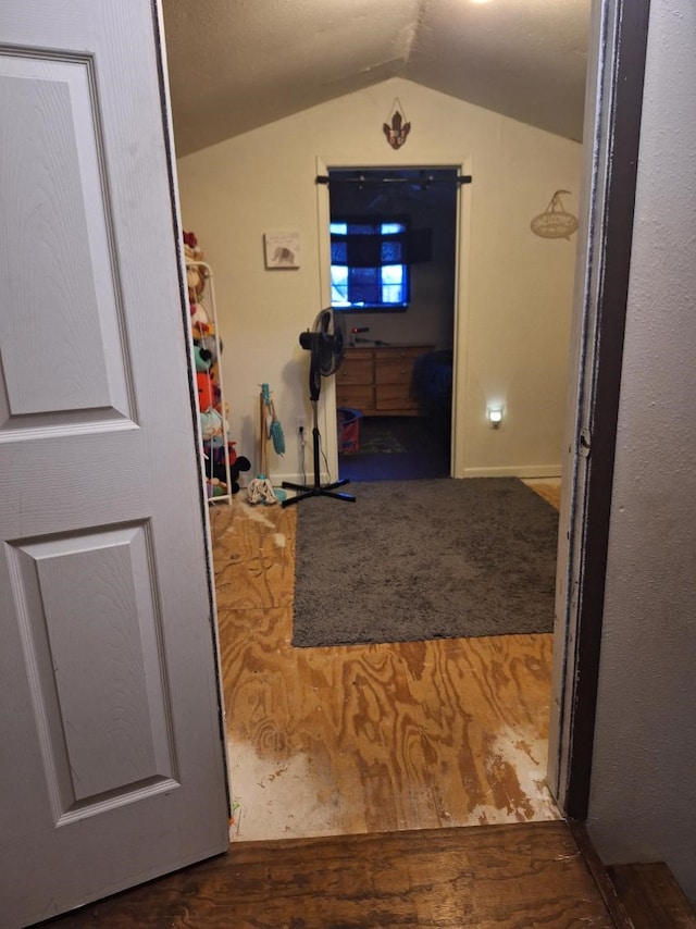 hallway with vaulted ceiling and dark wood finished floors