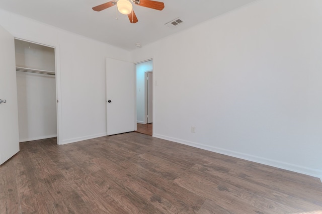 unfurnished bedroom featuring ceiling fan, dark wood-type flooring, and a closet