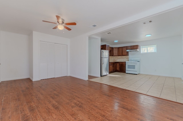 unfurnished living room with light wood-type flooring and ceiling fan