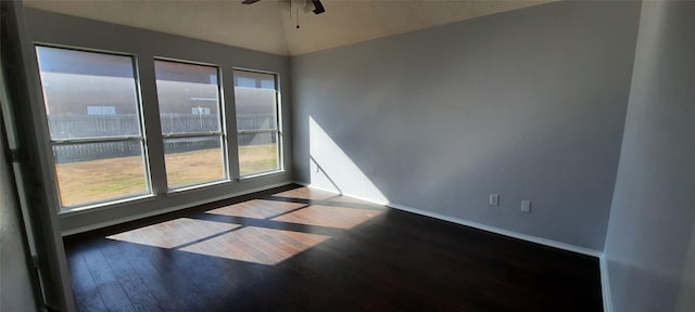 unfurnished room featuring ceiling fan, vaulted ceiling, baseboards, and wood finished floors