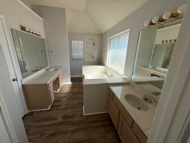 bathroom featuring lofted ceiling, wood finished floors, a textured ceiling, and a sink