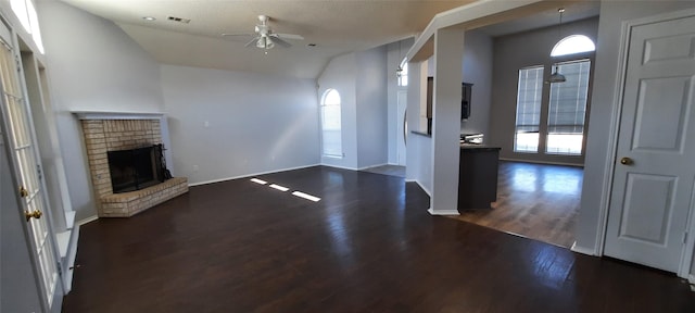 entryway with visible vents, lofted ceiling, dark wood-style floors, ceiling fan, and a fireplace