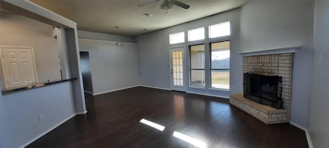 unfurnished living room with baseboards, a brick fireplace, wood finished floors, and a healthy amount of sunlight