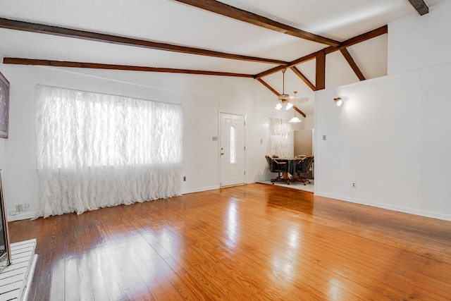 kitchen with a brick fireplace, light tile patterned floors, white cabinets, sink, and lofted ceiling with beams