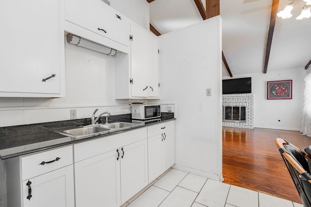 kitchen featuring a textured ceiling, white cabinets, white electric range, beamed ceiling, and stainless steel fridge with ice dispenser