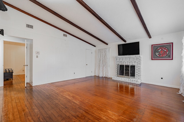 unfurnished living room featuring hardwood / wood-style floors and lofted ceiling with beams