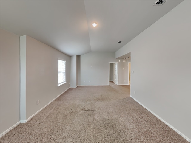 carpeted spare room featuring vaulted ceiling