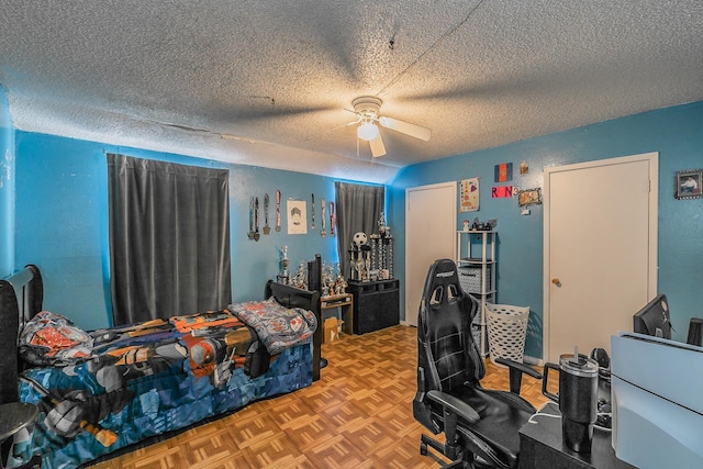 bedroom with ceiling fan, parquet flooring, and a textured ceiling