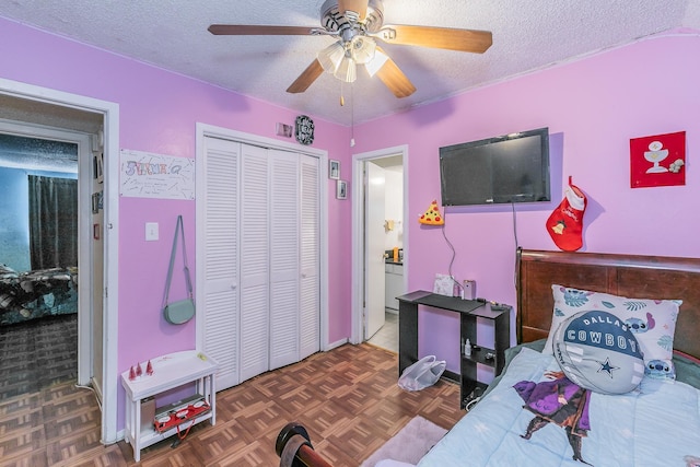 bedroom with dark parquet floors, a textured ceiling, a closet, and ceiling fan