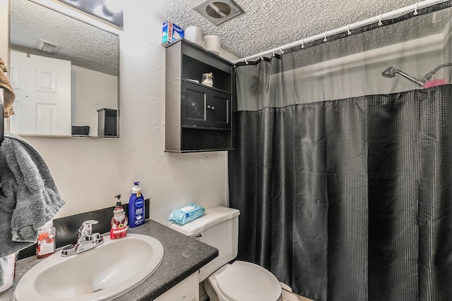 bathroom with a shower with curtain, toilet, a textured ceiling, and vanity