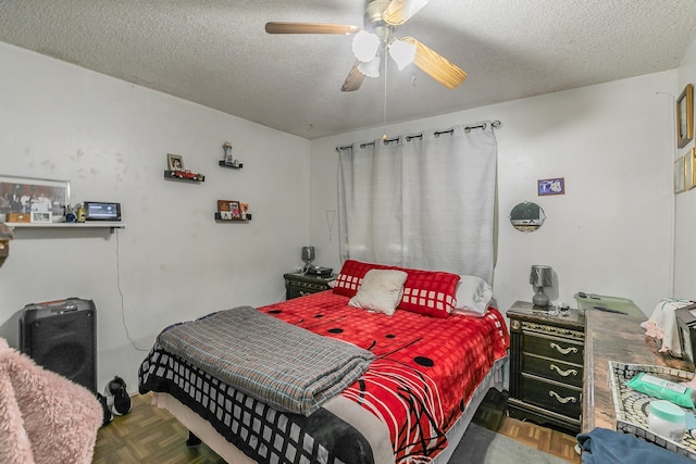 bedroom featuring a textured ceiling, parquet floors, and ceiling fan