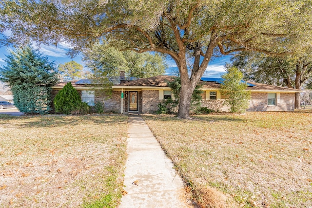 ranch-style house with a front lawn and solar panels