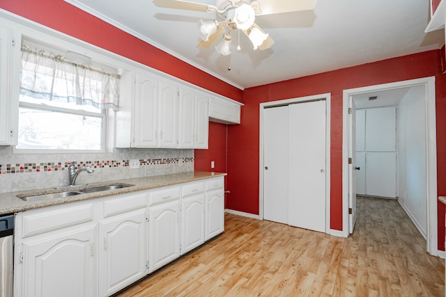 kitchen featuring dishwasher, sink, white cabinetry, and light hardwood / wood-style flooring