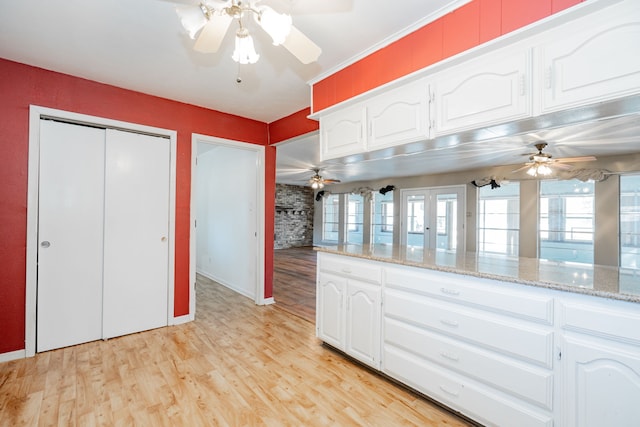 kitchen featuring light stone countertops, white cabinetry, and light hardwood / wood-style flooring