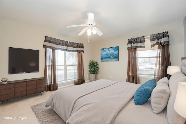 carpeted bedroom with ceiling fan and multiple windows